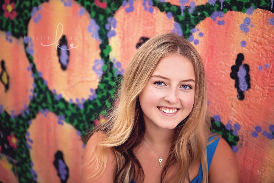 senior girl posing flower mural