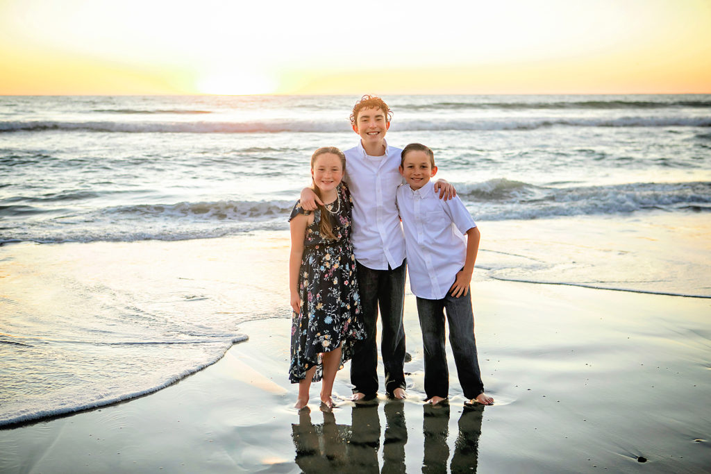 Photo by Carlsbad Family Beach Photographer. Photo may be of 3 people standing outdoors. 